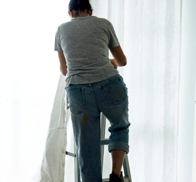 persona poniendo cortina en casa